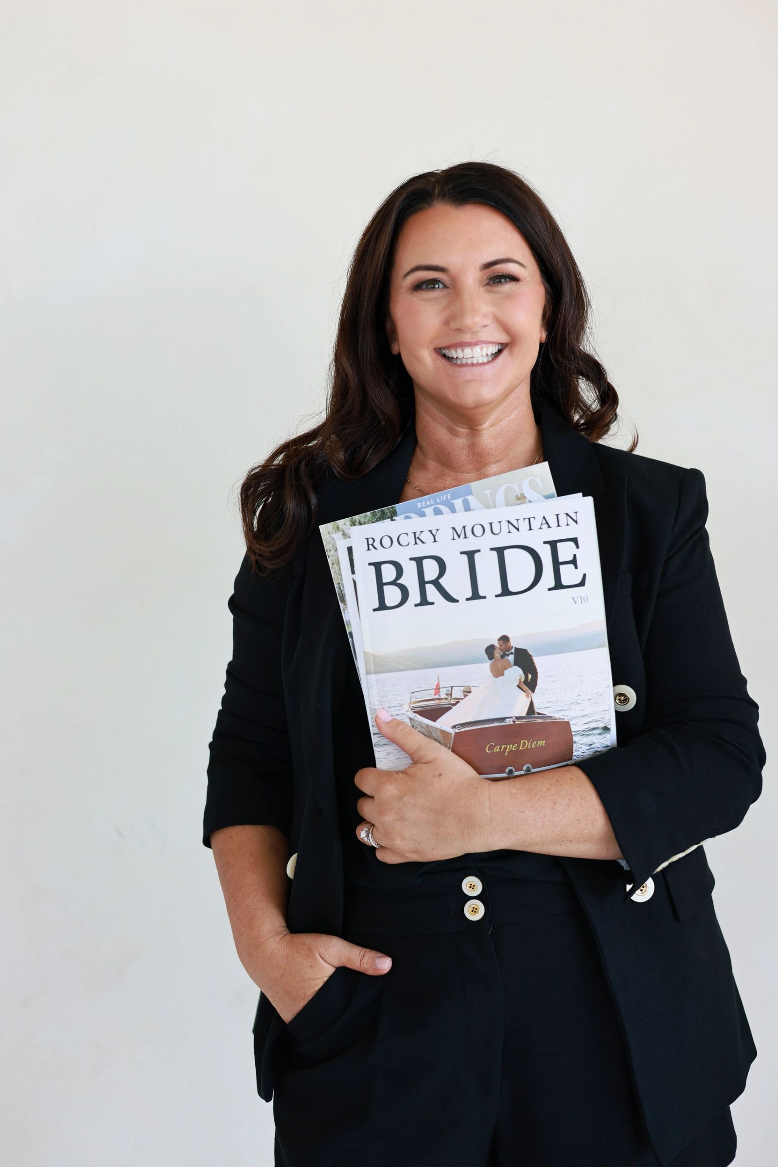 Kristi Bearden, principal planner and owner of Kristi Marie Events, holding wedding magazines