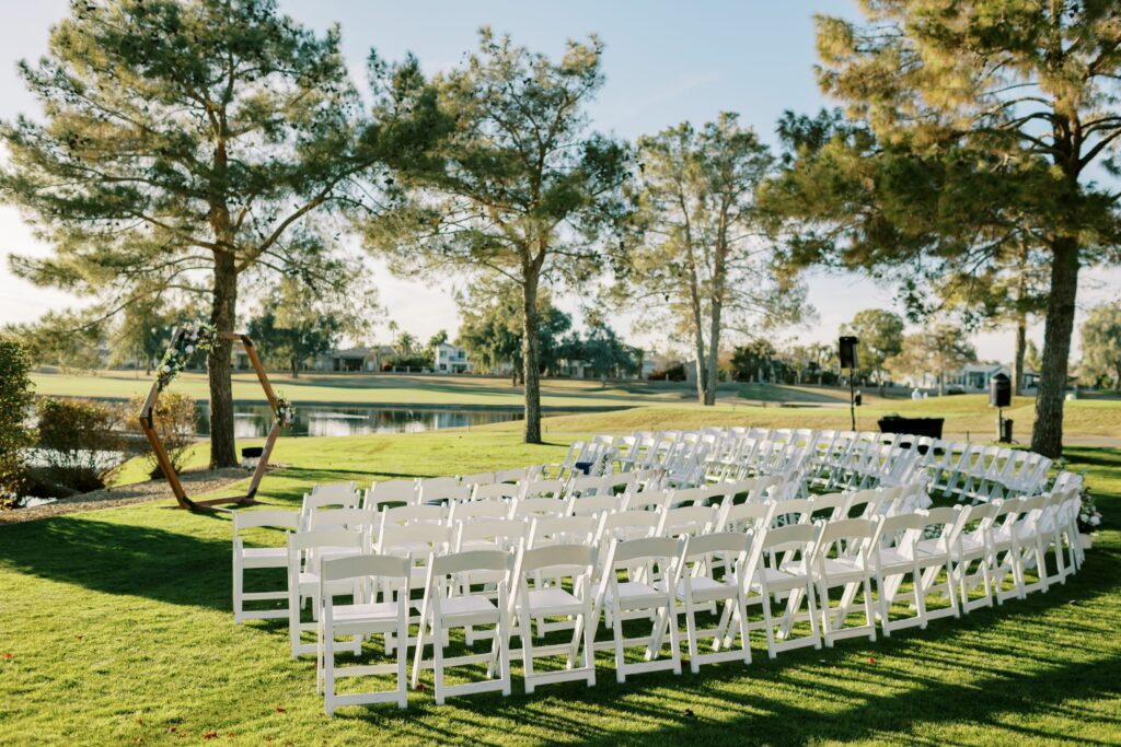 Chairs set on grass near water for wedding ceremony
